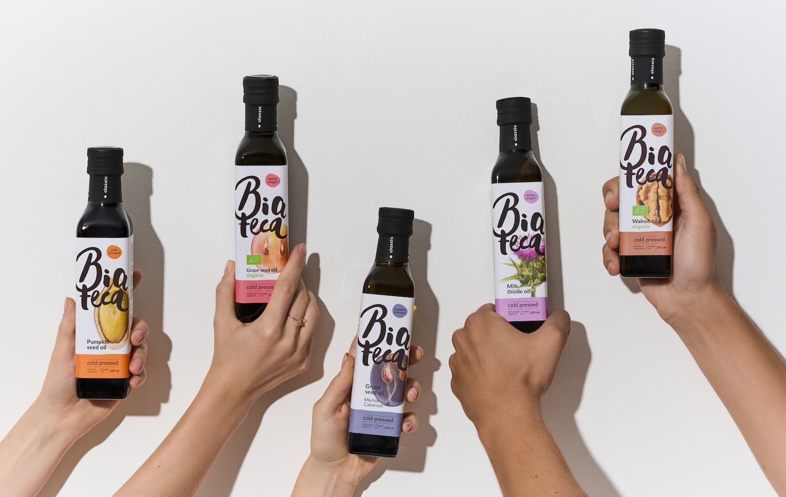 Hands holding Biateca oil bottles